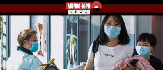 Um oficial de saúde (L) analisa os passageiros que chegam da China no aeroporto internacional de Changi, em Cingapura