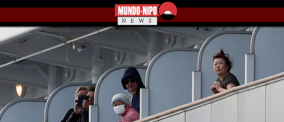 Os passageiros olham de suas cabines quando o navio de cruzeiro Diamond Princess